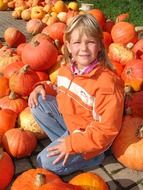 girl sitting on a pumpkin mountain