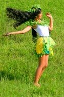 Girl with long black hair on a green meadow