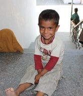 happy child Boy sits at staircase, India