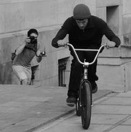 Black and white photo of a bicyclist and a man with a camera