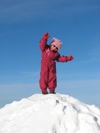 child on a pile of snow on a sunny day