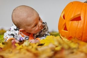 baby boy and carved pumpkin