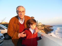 grandfather with grandson near the sea