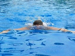 man swims in the pool