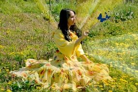 girl princess in yellow dress with butterflies in a field