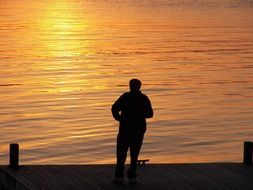 a man stands alone at sunset