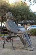 bronze statue of sitting on the bench man