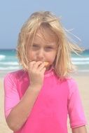 girl eating food near the sea