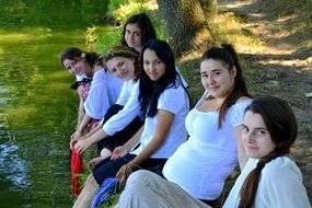 nice girls sitting near water lake