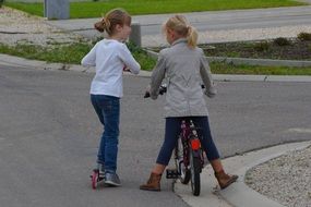 girls on bicycle and scooter