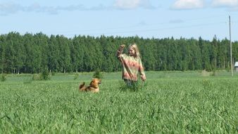 girl and dog playing in the field