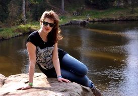 girl in glasses posing by the river