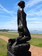 dark sculpture of ariadne on the shore