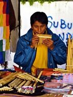 person in the market plays music with use antique panpipe