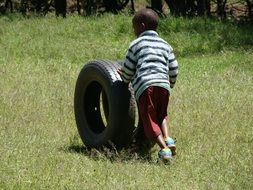 child playing with a tire on the outdoor