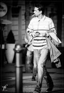black and white photo of a man with a cigarette on the street
