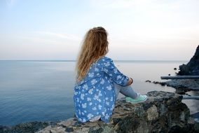 girl with long hair looks into the sea
