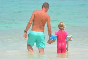 man with child standing in water