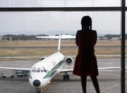 girl through the window looks at the plane