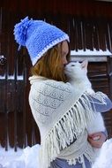 girl with a white cat in her arms in winter