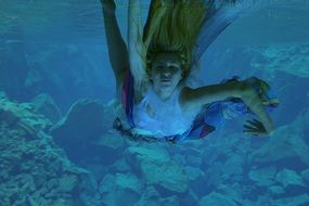 girl mermaid is swimming underwater