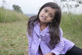 girl in a purple jacket on the meadow