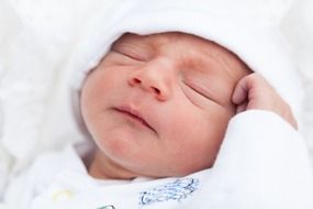 sleeping newborn in white clothes