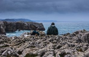 asturias fisherman sitting on the rocks