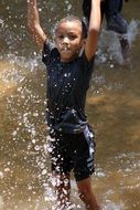 happy boy is playing in the water
