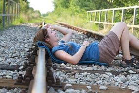 girl is lying on the rails