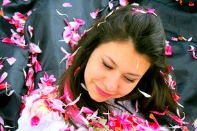 the beautiful girl strewn with pink petals