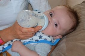 baby is drinking milk from a bottle