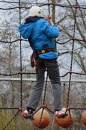 child in helmet climbing rope