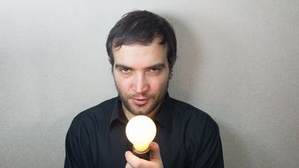 man with switched on lightbulb