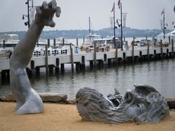 The Awakening sculpture in sand at pier