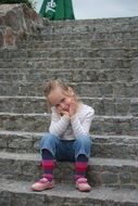 the girl is sitting on the stairs in good weather