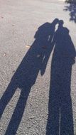 two shadows of friends on the pavement