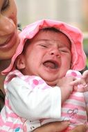 Small crying baby in the hands