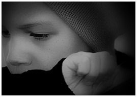 black and white portrait of a boy with sad eyes