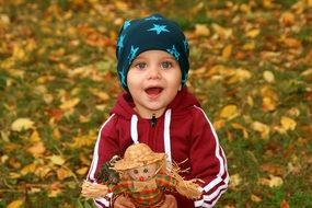 child with a doll in hands on nature background in the park