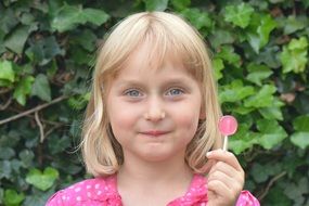 portrait of girl child with lollipop candy in garden