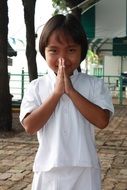 little girl prays in a temple in thailand