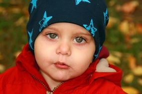 Portrait of a green-eyed child on the background of nature in the park