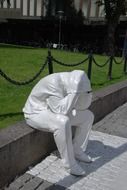 statue of a man sitting on a parapet