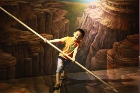 the boy is balancing in the hall of optical illusions