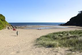 distant people on sand beach at summer