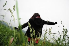 girl in a black jacket on a green field