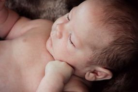 cute newborn baby boy sleeping on his back