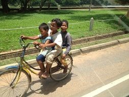 children riding a bike in cambodia