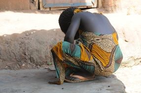 african girl sitting near the wall